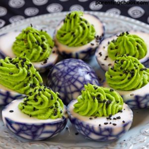 Halloween spiderweb deviled eggs with green filling