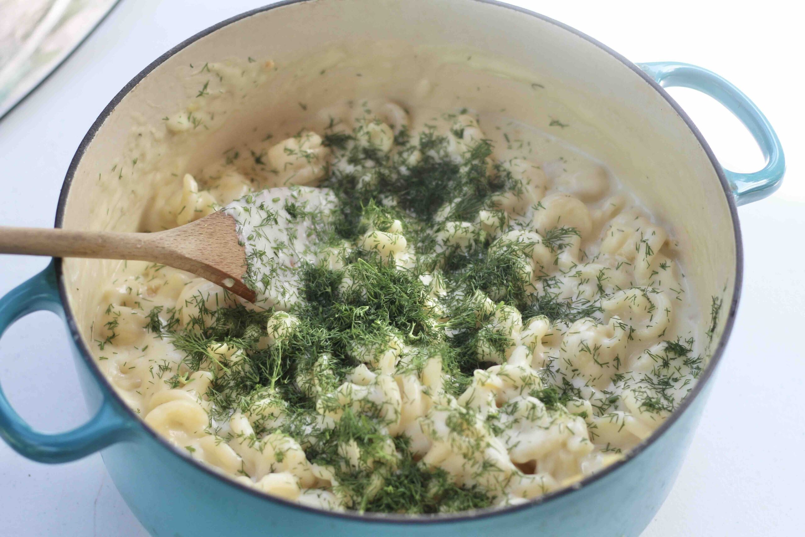 Mixing pasta, cheese and dill