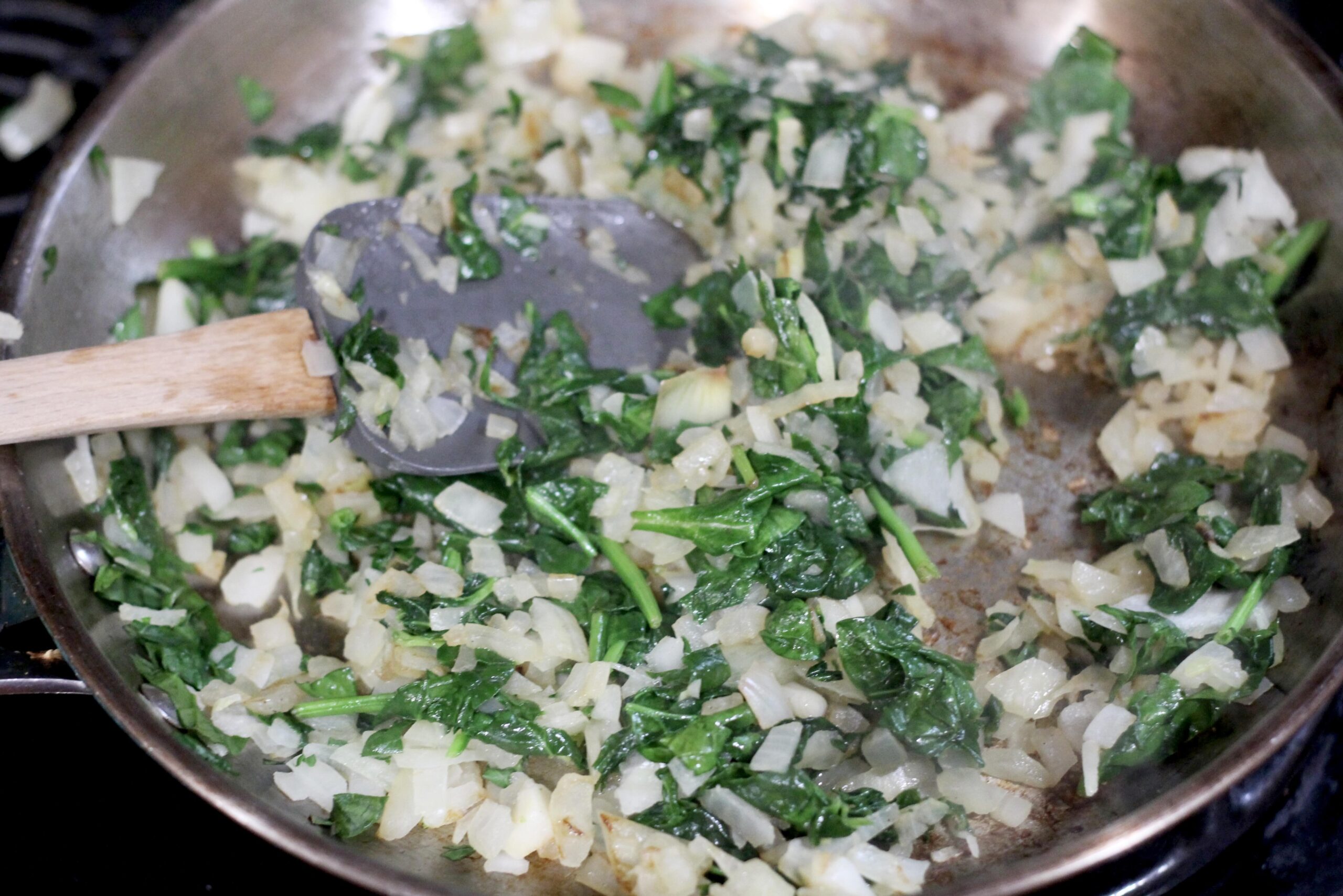 Onions and spinach in a skillet