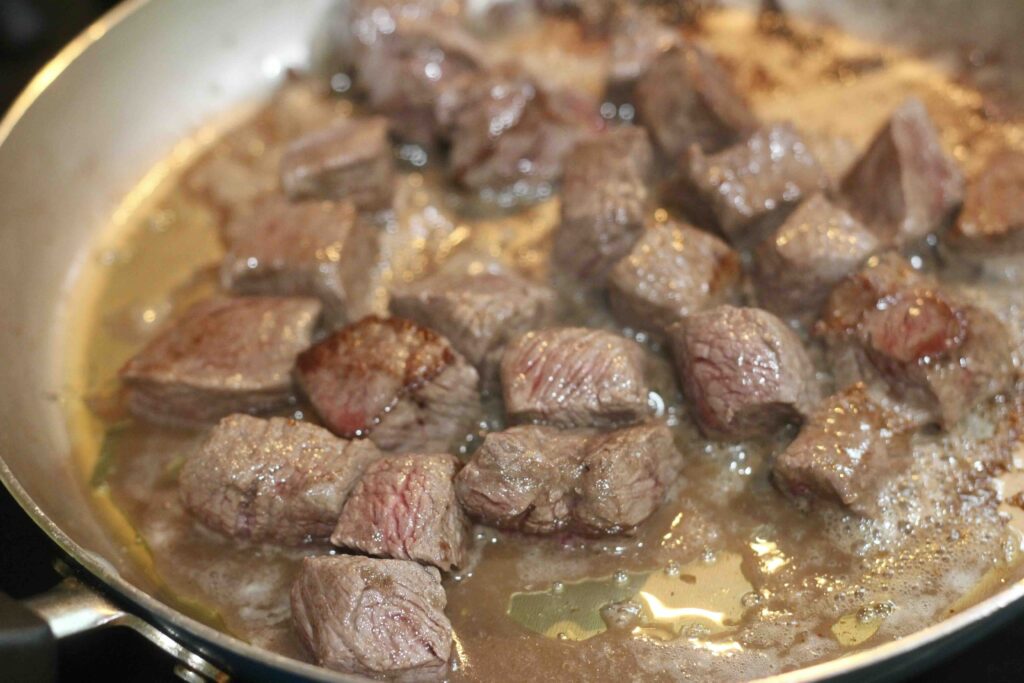 Angus beef pieces in a skillet