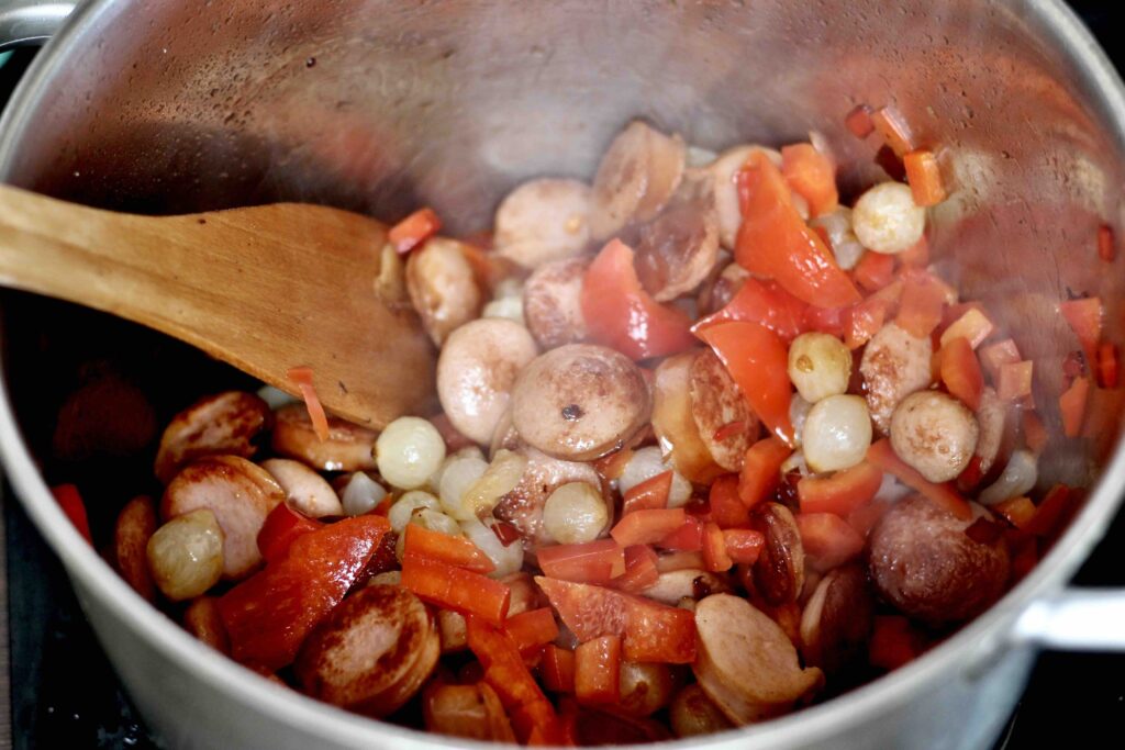 Frying vegetables and sausage for soup